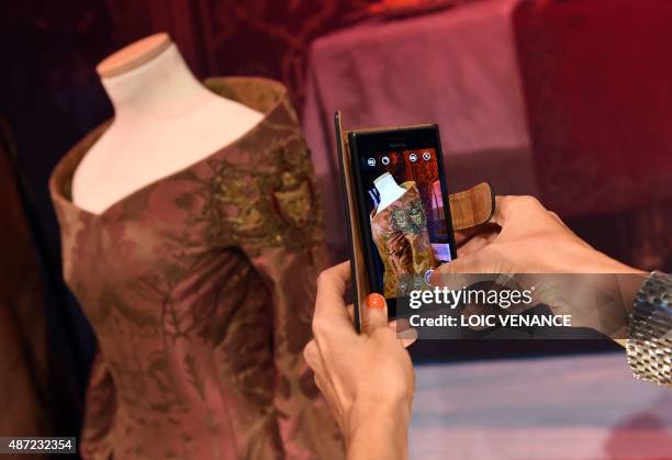 Visitor takes a photo of a costume on September 7, 2015 during the opening of an exhibition dedicated to HBO's television medieval fantasy series...