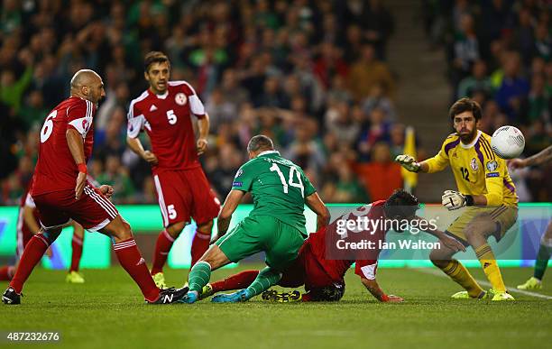 Jonathan Walters of the Republic of Ireland beats Giorgi Navalovski and goalkeeper Nukri Revishvili of Georgia to score their first goal during the...