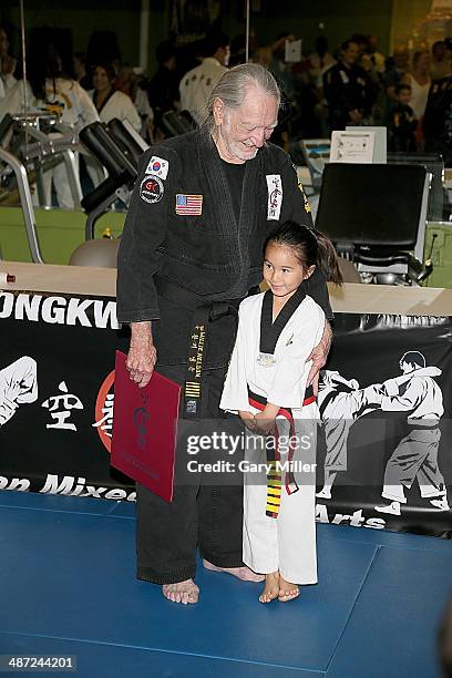 Willie Nelson poses with a fellow student during Nelson's 5th Degree black belt award ceremony at Master Martial Arts on April 28, 2014 in Austin,...