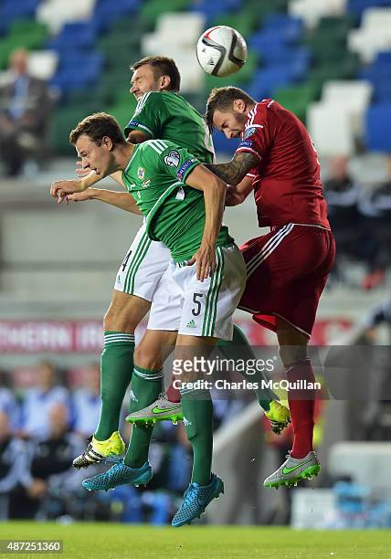 Jonny Evans and Gareth McAuley of Northern Ireland jump with XXXTamas Kadar of Hungary during the Euro 2016 Group F qualifying match at Windsor Park...