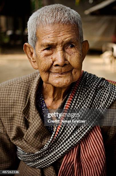 Portrait of an elderly woman in front of her home.