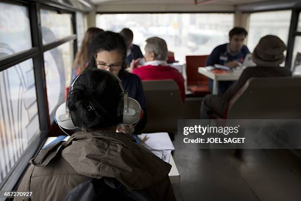 Woman gets her hearing tested by a volunteer in the bus of the association ''les Enfants du Canal'' on April 28, 2014 in Paris. The operation aims at...