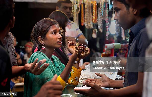 Year old Maisha buys items to make jewelry out of to sell on the beach April 14, 2014 in Cox's Bazar, Bangladesh. A group of 10-12 year old female...