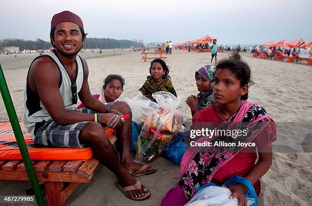 Rashed Alam talks with beach vendors after surfing April 12, 2014 in Cox's Bazar, Bangladesh. A group of 10-12 year old female beach vendors, most of...