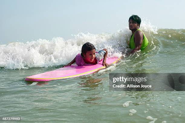 Rashed Alam teaches 12 year old Shobhemeheraj to surf April 15, 2014 in Cox's Bazar, Bangladesh. A group of 10-12 year old female beach vendors, most...