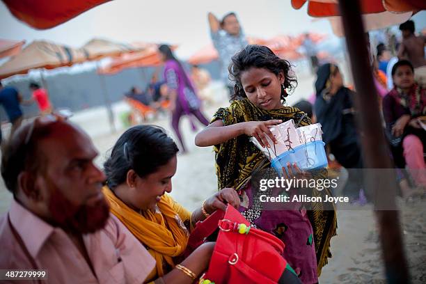 Year old Aisha, who has been working for 4 years, sells jewelry on the beach April 12, 2014 in Cox's Bazar, Bangladesh. A group of 10-12 year old...