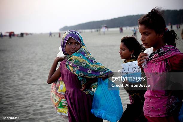 Year old Jahanara, 10 year old Aisha, and 12 year old Shuma sell items on the beach April 12, 2014 in Cox's Bazar, Bangladesh. A group of 10-12 year...