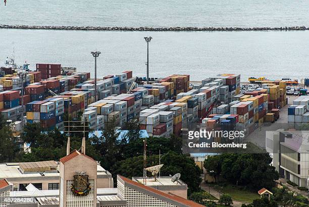 Shipping containers sit on the dockside at the Port of Conakry in Conakry, Guinea, on Saturday, Sept. 5, 2015. While Guinea produces bauxite, which...