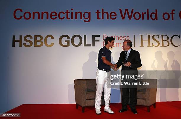 Matteo Manassero of Italy presents Peter Dawson, Chief Executive of The R&A with a special Lifetime Achievement Award during the 2014 HSBC Golf...