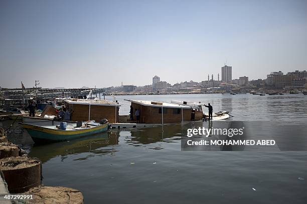 Palestinian Hamas policemen inspect the Gaza's Ark, a Palestinian-built protest boat which was preparing to run Israel's naval blockade, after it was...