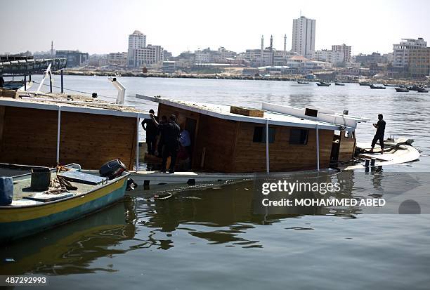 Palestinian Hamas policemen inspect the Gaza's Ark, a Palestinian-built protest boat which was preparing to run Israel's naval blockade, after it was...