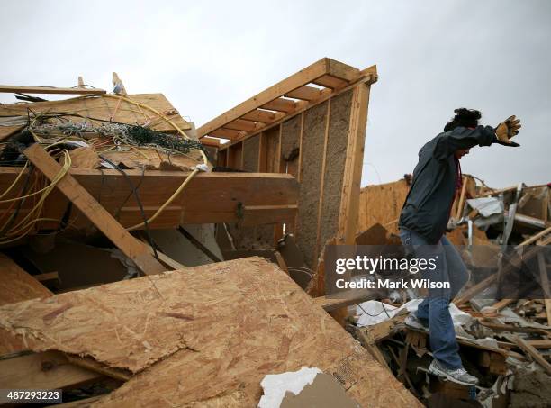 Michelle McGee walks over debris to inspect her home that was destroyed by a tornado on Sunday, April 29, 2014 in Vilonia, Arkansas. After deadly...