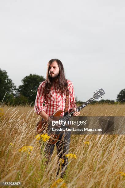 Portrait of British blues guitarist Marcus Bonfanti photographed with his Gibson SG electric guitar in a field in rural Norfolk, on July 30, 2013.