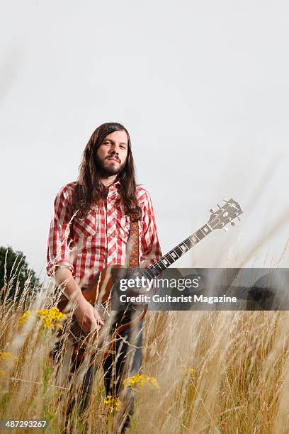 Portrait of British blues guitarist Marcus Bonfanti photographed with his Gibson SG electric guitar in a field in rural Norfolk, on July 30, 2013.