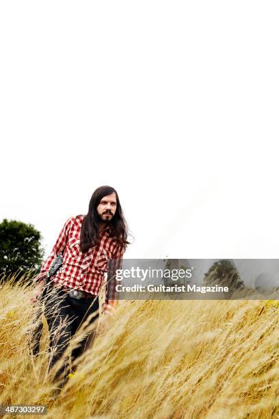 Portrait of British blues guitarist Marcus Bonfanti photographed with his Gibson SG electric guitar in a field in rural Norfolk, on July 30, 2013.