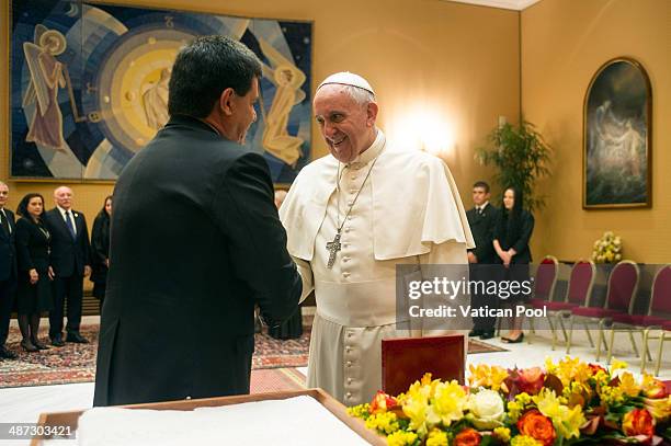 Pope Francis exchanges gifts with President of Paraguay Horacio Manuel Cartes Jara during an audience at the Paul VI Hall on April 29, 2014 in...