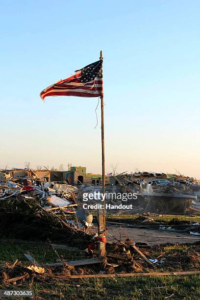 In this handout provided by the Arkansas National Guard, an American flag stands amongst the rubble of a community following a deadly tornado April...