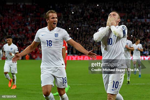 Wayne Rooney of England celebrates scoring his team's second goal breaking the record of 49 goals set by Sir Bobby Charlton with Harry Kane during...