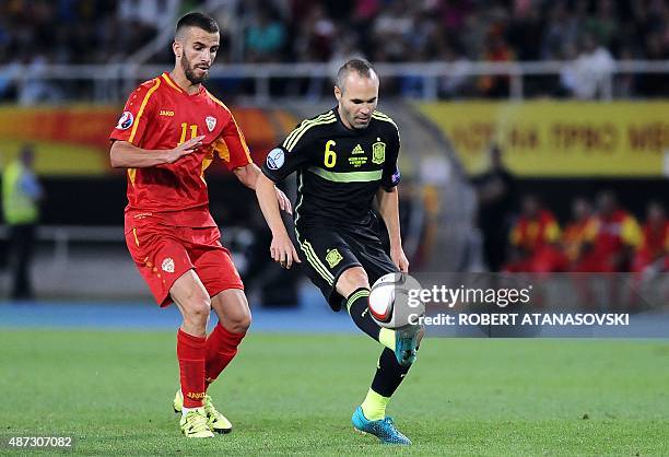 Macedonia's Feran Hasani vies with Spain's Andres Iniesta during the Euro 2016 Group D qualifying football match between FYR Macedonia and Spain at...