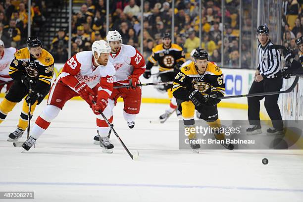 Carl Soderberg and Justin Florek of the Boston Bruins skates after the puck against Johan Franzen and Brian Lashoff of the Detroit Red Wings in Game...