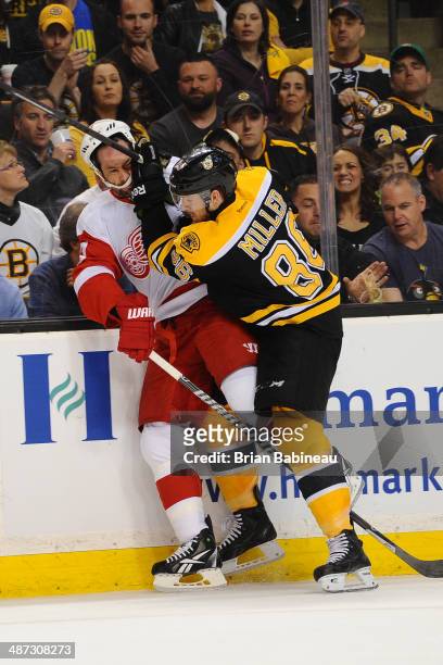 Kevan Miller of the Boston Bruins checks against David Legwand of the Detroit Red Wings in Game Five of the First Round of the 2014 Stanley Cup...