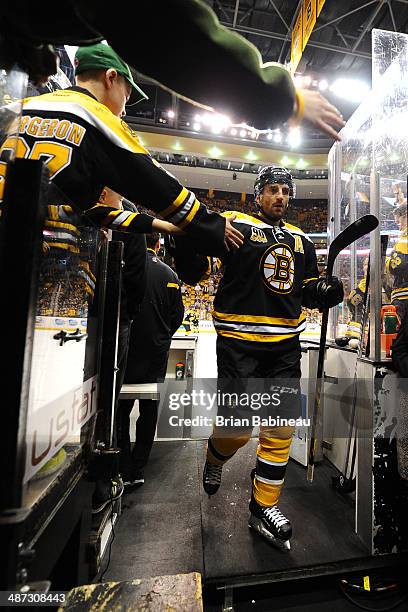 Patrice Bergeron of the Boston Bruins high fives fans after warm ups against the Detroit Red Wings in Game Five of the First Round of the 2014...