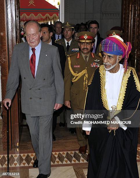 Omani leader Sultan Qaboos bin Said walks alongside Spanish King Juan Carlos during a welcome ceremony in Muscat on April 29, 2014. AFP PHOTO/MOHAMED...
