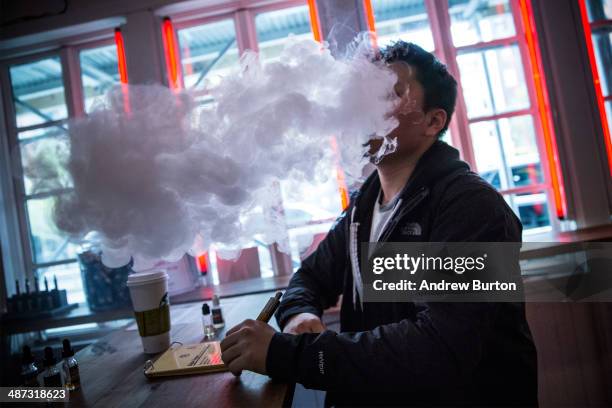 Tom Kim vapes, or smokes an electronic cigarette, at Henley Vaporium on April 29, 2014 in New York City. A new law that goes into effect today in New...