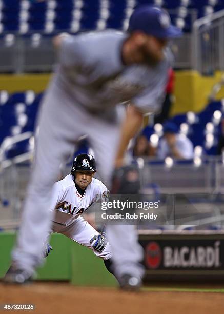 Ichiro Suzuki of the Miami Marlins watches pitcher Taylor Jungmann of the Milwaukee Brewers as he leads off first base during the fourth inning of...