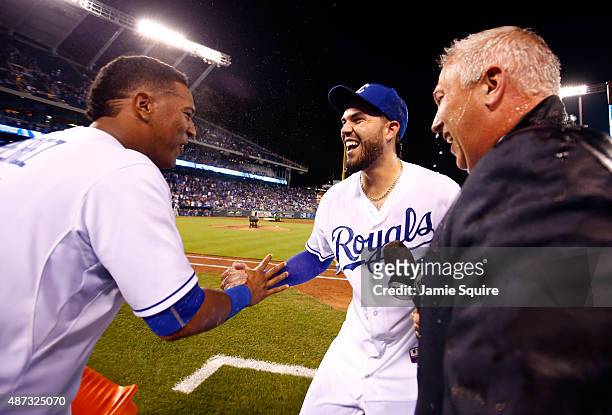 Salvador Perez of the Kansas City Royals celebrates with Eric Hosmer after dumping a bucket of water over the heads of Hosmer and FOX broadcaster...