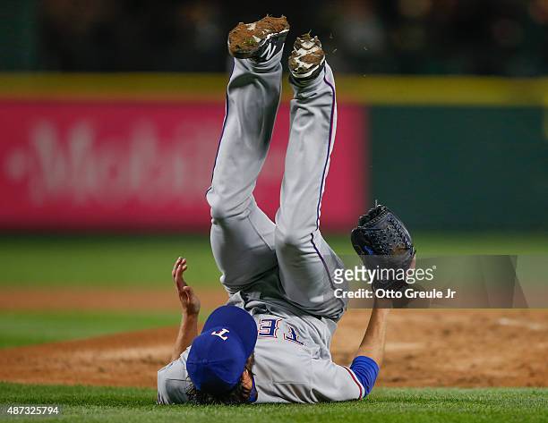Starting pitcher Cole Hamels of the Texas Rangers tumbles off the mound after being hit with a comebacker off the bat of Jesus Sucre of the Seattle...