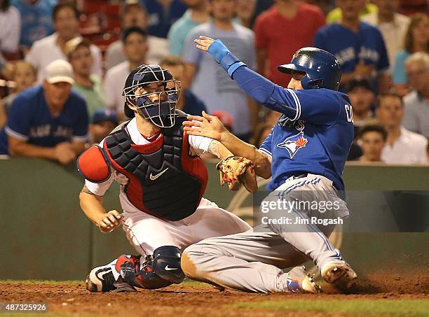 Chris Colabello of the Toronto Blue Jays scores as Blake Swihart of the Boston Red Sox is unable to make the play at the plate in the tenth inning at...