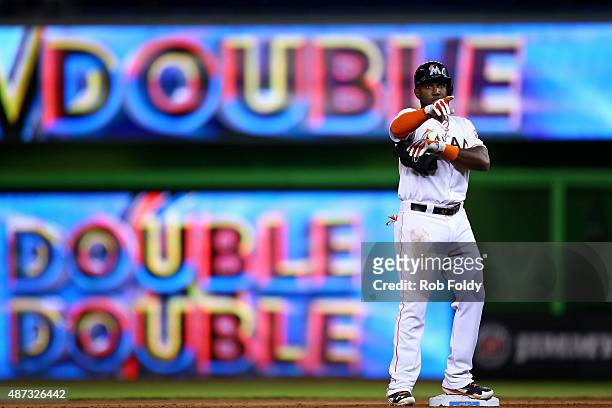 Marcell Ozuna of the Miami Marlins motions to the dugout after hitting a double during the seventh inning of the game against the Milwaukee Brewers...