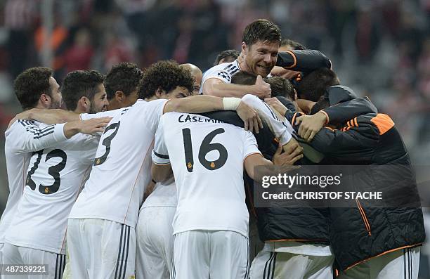 Real Madrid's midfielder Xabi Alonso celebrates with teammates winning 0-4 the UEFA Champions League second-leg semi-final football match FC Bayern...