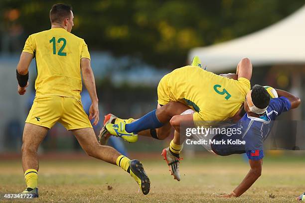 Liam McNamara of Australia watches on as Simon Kenewell of Australia tackles Mathew Taula of Samoa during the boys match between Australia and Samoa...