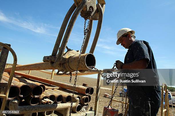 Israel Garcia with Arthur & Orum Well Drilling prepares to install a new pipe on a rig while drilling a new well at a farm on April 29, 2014 near...