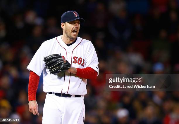 John Lackey of the Boston Red Sox reacts after giving up a walk in the fifth inning against the Tampa Bay Rays during the game at Fenway Park on...