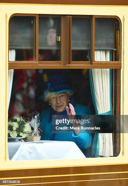 Queen Elizabeth II waves to crowds at Waverley Station from the window of the steam locomotive 'Union of South Africa' on September 9, 2015 in...
