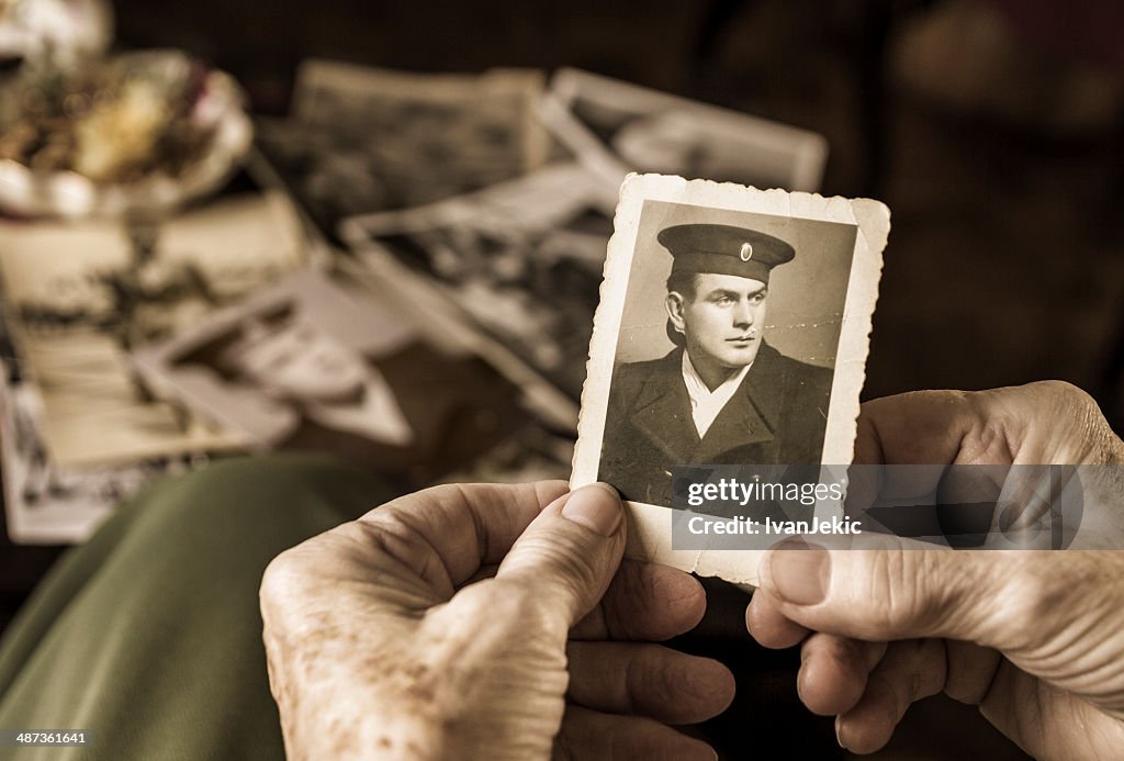 Senior woman holding dear photograph of her husband