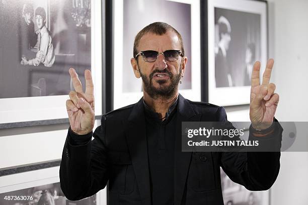 British musician Ringo Starr of legendary band The Beatles poses in front of an exhibition of photographs he took during his life during a photo call...