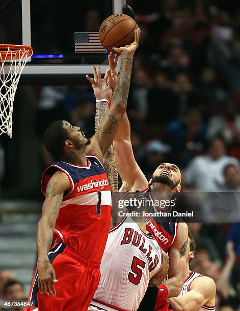 Carlos Boozer of the Chicago Bulls battles for a rebound between Trevor Ariza and Marcin Gortat of the Washington Wizards in Game Five of the Eastern...