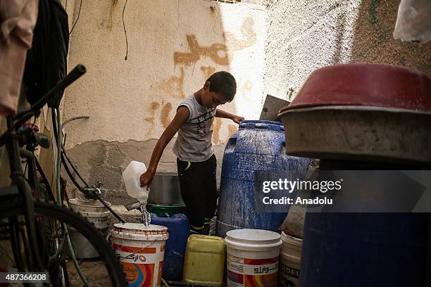 Boy fills a bucket with water brought by a water truck in Gaza City, Gaza on September 9, 2015. At least 120,000 Palestinians face water crisis just...