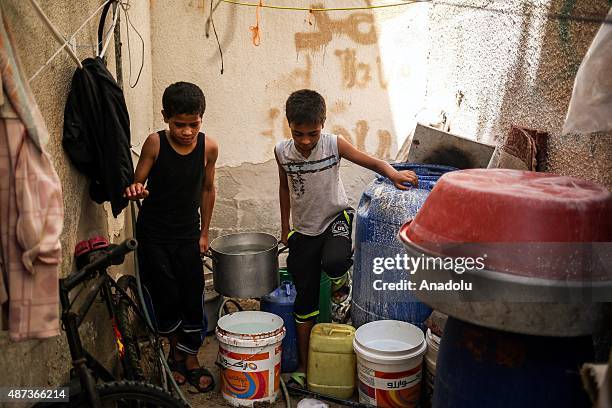 Boys fill buckets with water brought by a water truck in Gaza City, Gaza on September 9, 2015. At least 120,000 Palestinians face water crisis just...