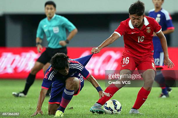 Takagi Akito of Japan vies with Cao Yongjing of China during a match between China and Japan of 2015 "Changan Ford Cup" CFA International Youth...