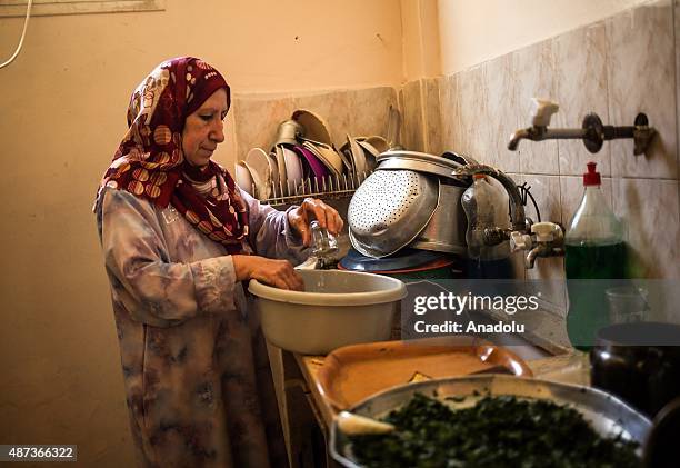 Woman uses water that her son brought with a bucket to wash the dishes in Gaza City, Gaza on September 9, 2015. At least 120,000 Palestinians face...