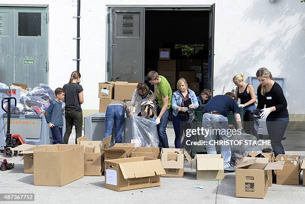 Helpers collect donations in front of the "Bayernkaserne" in Munich, southern Germany, on September 9, 2015. Hundres of refugees arrive daily in...