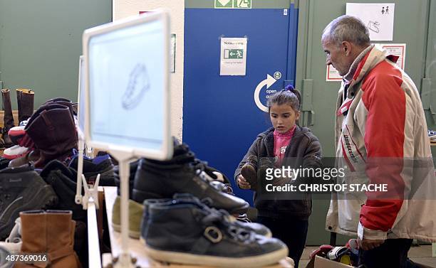 Refugees search for shoes at the "Bayernkaserne", where donations for migrants have been collected, in Munich, southern Germany, on September 9,...