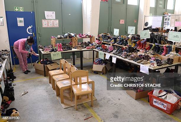 Migrant looks for shoes at the "Bayernkaserne", where donations for migrants have been collected, in Munich, southern Germany, on September 9, 2015....