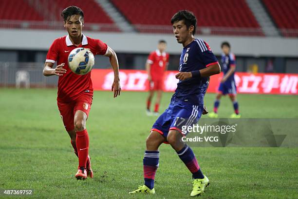 Feng Boxuan of China vies with Takagi Akito of Japan during a match between China and Japan of 2015 "Changan Ford Cup" CFA International Youth...