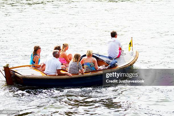 small sight seeing tourboat in open havenfront amsterdam - amsterdam mensen boot stockfoto's en -beelden